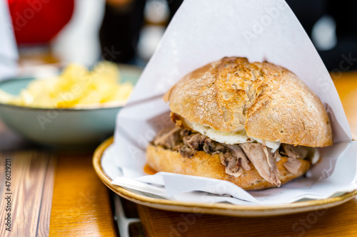 Delicious bun with delicate piglet and egg with chips aside photo