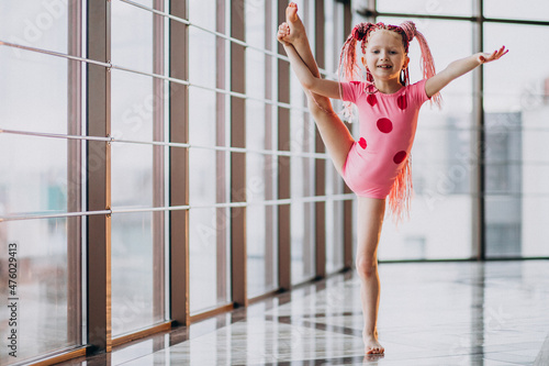 Schilderij op canvas Cute little girl doing gymnastics on mat in studio