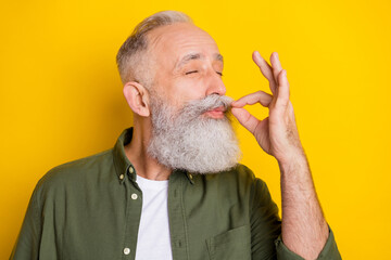 Photo portrait of elder man eating delicious food showing italian gesture isolated bright yellow color background