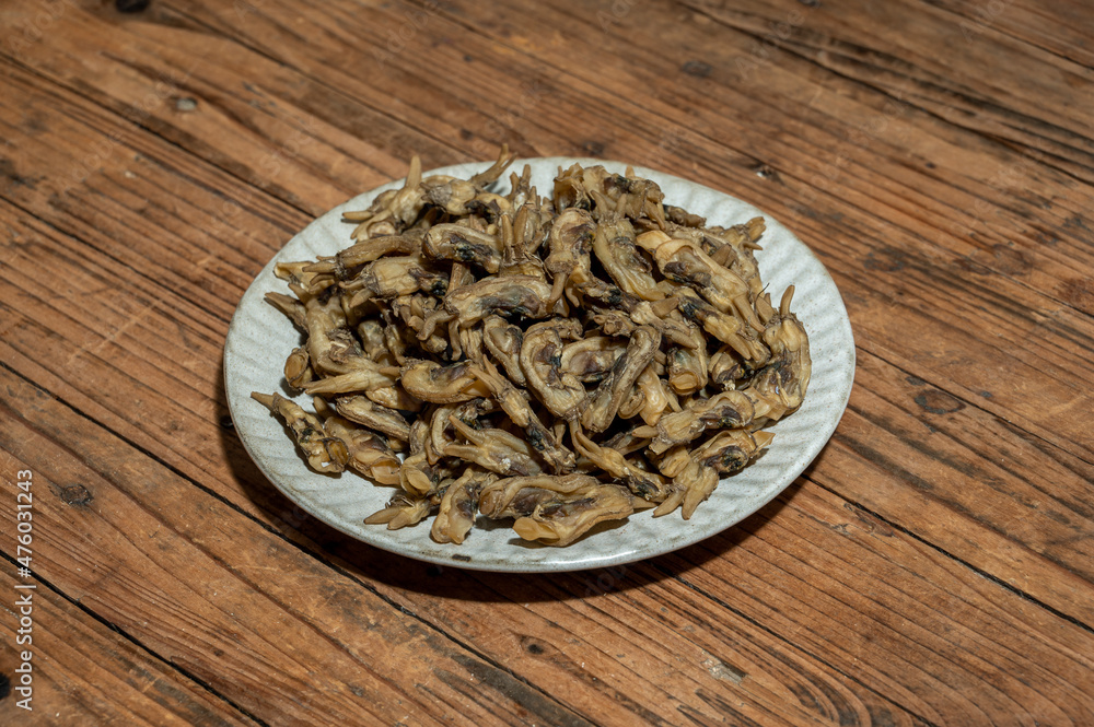 Dried razor clams in containers on wood grain countertops Dried razor clams in containers on wood grain countertops