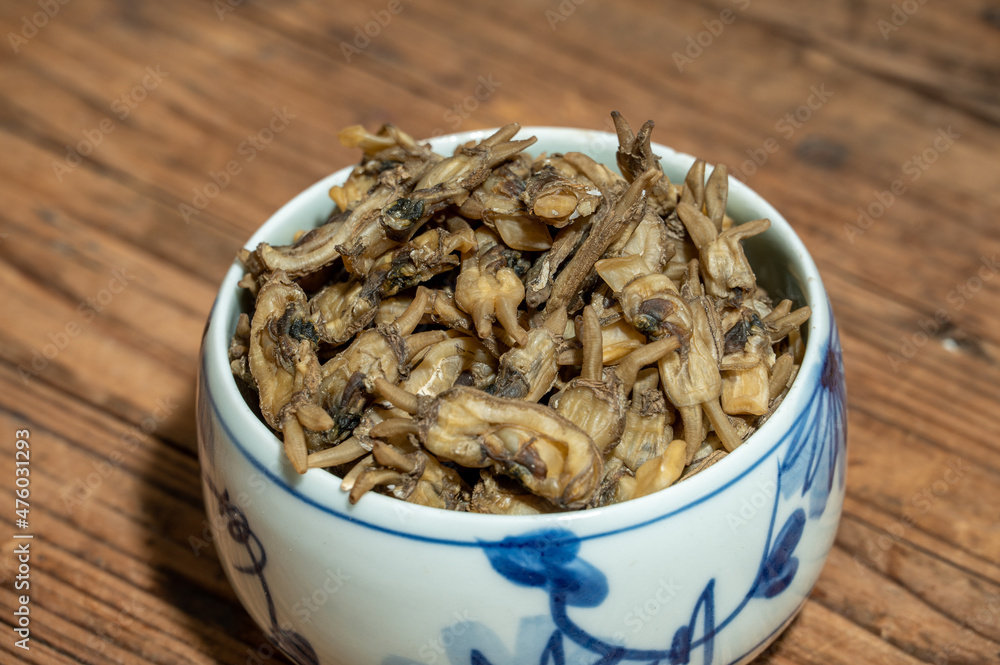 Dried razor clams in containers on wood grain countertops Dried razor clams in containers on wood grain countertops