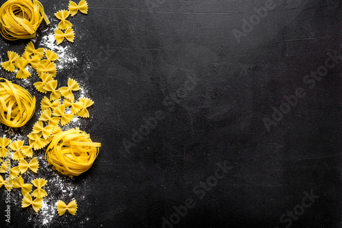 Different tipes of pasta with flour ready for cooking, flat lay