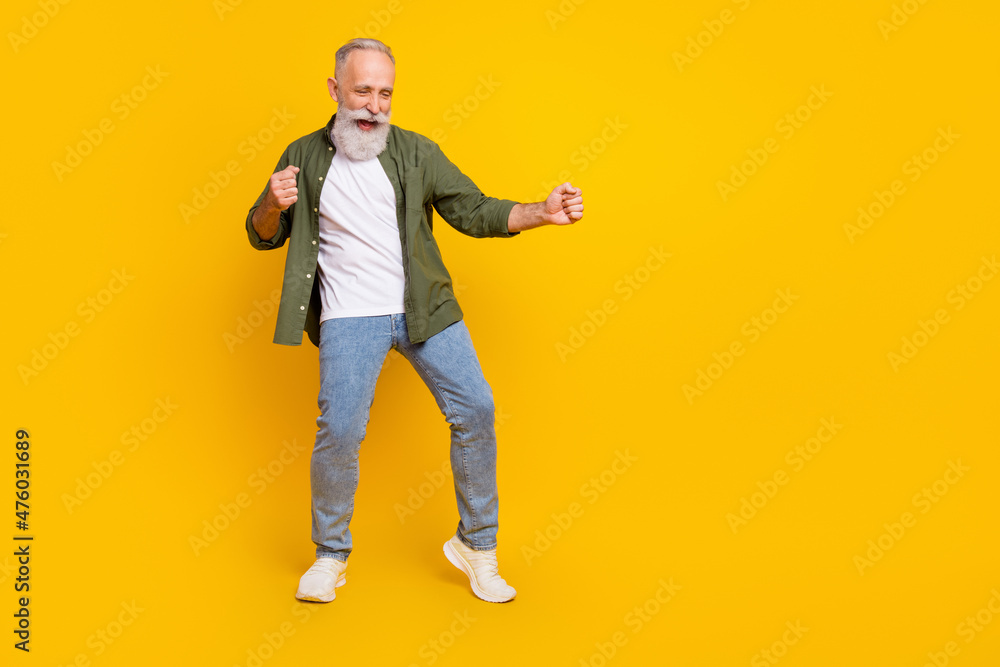 Full length body size photo of dancing elder man relaxing at party on holiday isolated bright yellow color background Full length body size photo of dancing elder man relaxing at party on holiday isolated bright yellow color background