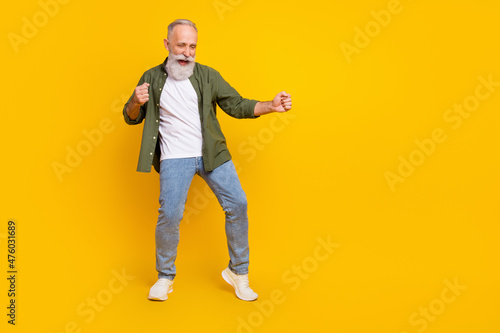 Full length body size photo of dancing elder man relaxing at party on holiday isolated bright yellow color background