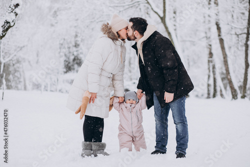 Young family with little daughter in a winter forest full of snow © Petro