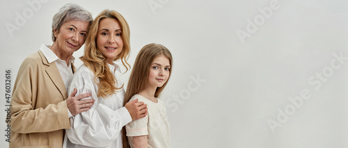 Side view of three females posing in white studio