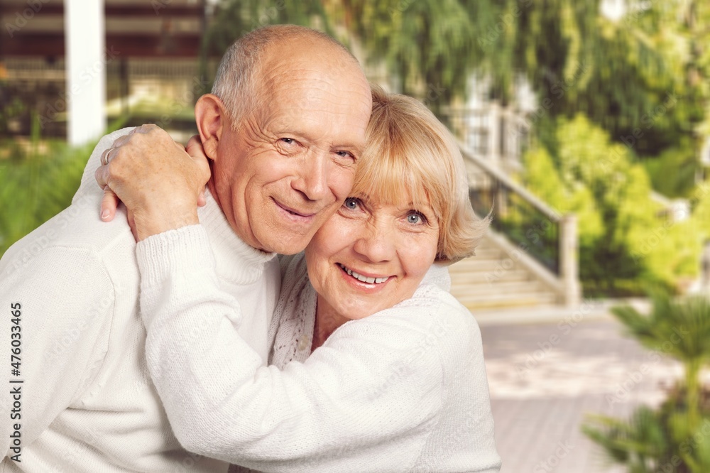 Senior couple spending time in sunny garden together embracing and smiling. Senior couple spending time in sunny garden together embracing and smiling.