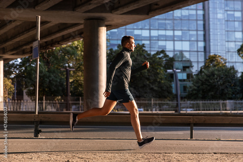 fitness  sport and healthy lifestyle concept - young man running outdoors under bridge
