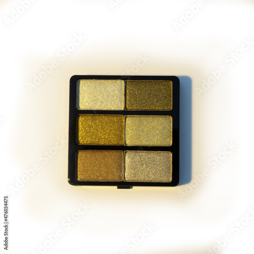 Mini palette of khaki green and silver eyeshadows. Isolated image on a white background. Nobody.