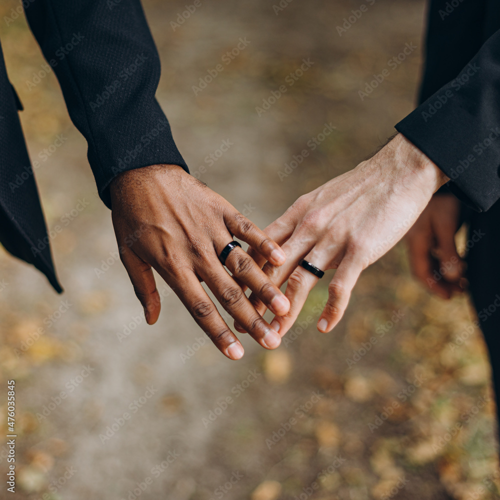 European Gay Couple holding hands, homosexual marriage wedding day. Gentle touch of a same sex couple - obrazy, fototapety, plakaty 