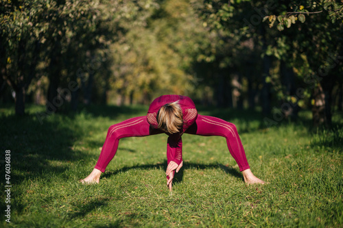 beautiful girl in sportswear doing yoga poses on the alley in the autumn park, balance, fitness, stretching and relaxation