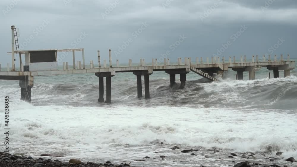 hurricane. Shots of pier with crashing waves. Sea foam, splashes of water, waves beating on shore. Storm at sea in resort town of Batumi. Waves crash against a reinforced concrete pier. slow motion hurricane. Shots of pier with crashing waves. Sea foam, splashes of water, waves beating on shore. Storm at sea in resort town of Batumi. Waves crash against a reinforced concrete pier. slow motion