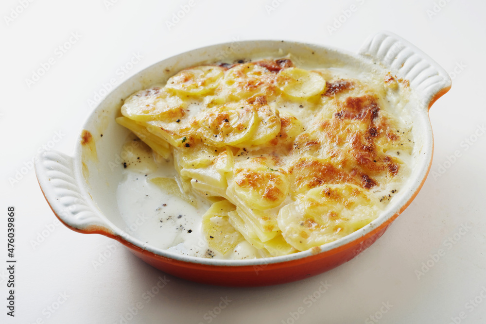 Appetizing French dish with sliced potatoes and sauce in casserole