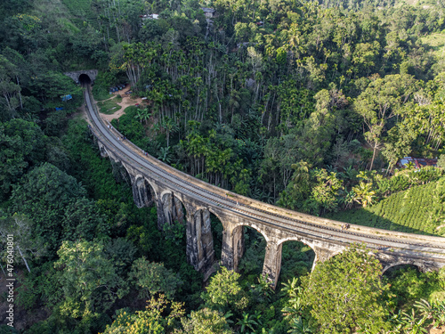 Sri Lanka. The attraction is the ancient railway Nine-arch Demodara Bridge in the midst of a dense tropical forest. Shooting from the air on a drone. Sunny day, sunset.
