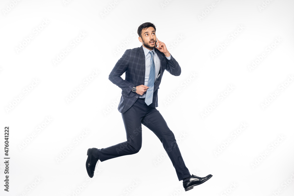 pensive businessman in suit jumping and talking on smartphone on white. pensive businessman in suit jumping and talking on smartphone on white.