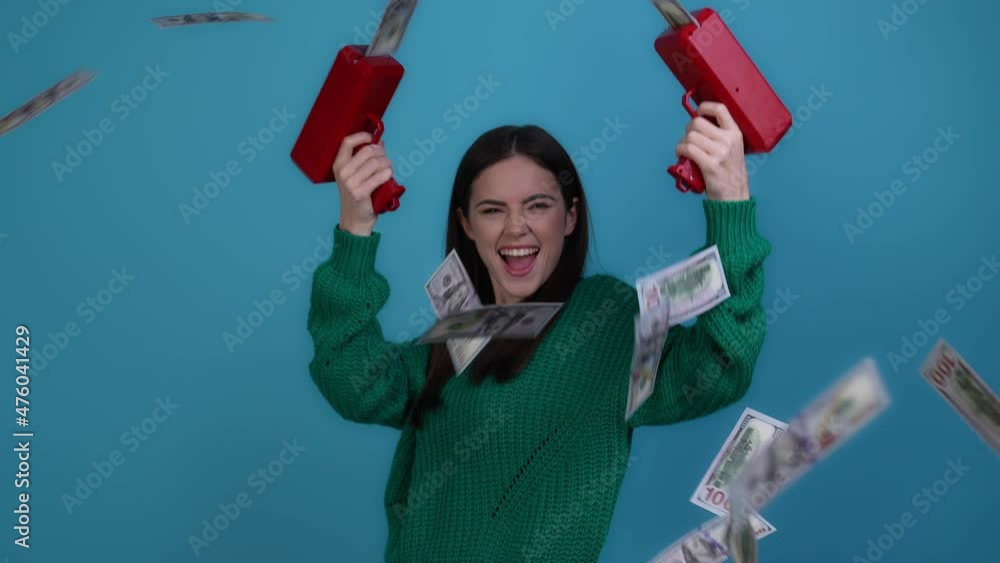 Delighted lady shoot pistol air earnings money isolated blue color background Delighted lady shoot pistol air earnings money isolated blue color background