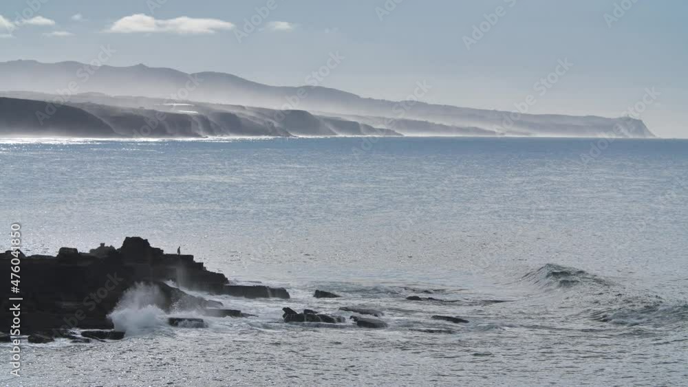 Sea with fog on the hills and man standing on the rocks Sea with fog on the hills and man standing on the rocks