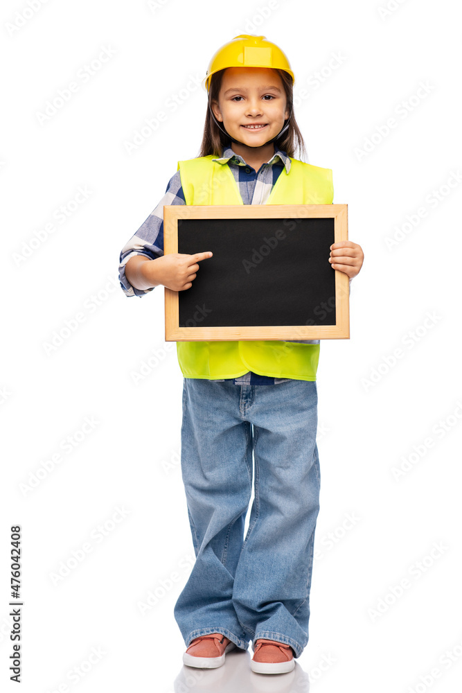 building, construction and profession concept - smiling little girl in protective helmet and safety vest holding chalkboard over white background building, construction and profession concept - smiling little girl in protective helmet and safety vest holding chalkboard over white background