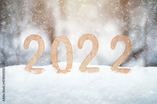 2022 plywood new year numbers stand in a snowdrift outdoors with snowflakes