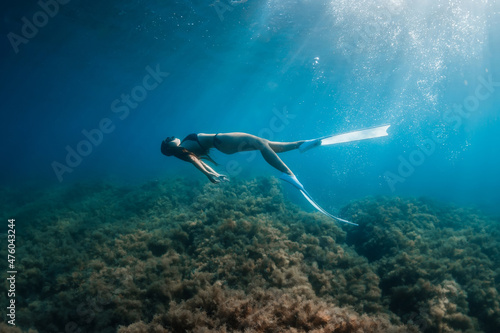 Free diver woman with fins posing underwater. Freediving with young girl