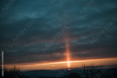 a natural phenomenon of a light column. the light from the sun refracted in the frosty air. beautiful sunset sky in winter