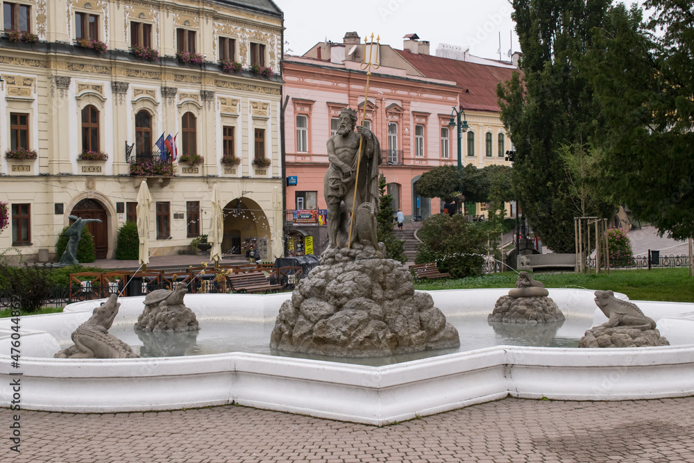 Old building in town with decorative milling cutters. View of the fountain with stone Neptune and other monsters.