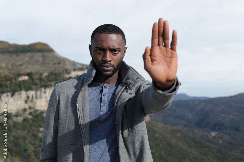 Man with black skin gesturing stop in winter in nature Man with black skin gesturing stop in winter in nature
