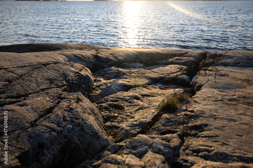 Beautiful natural Scandinavian landscape. Rocky shore at the Baltic sea with sunlight and water. Sunny late autumn or winter day in the nature in Sweden, Stockholm archipelago. Bjorno nature reserve photo