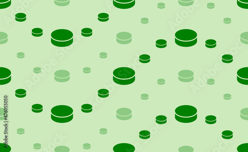 Seamless pattern of large and small green hockey pucks. The elements are arranged in a wavy. Vector illustration on light green background