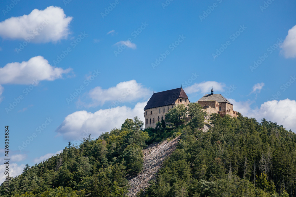 Tocnik, Central Bohemia, Czech Republic, 31 July 2021: Ruins of medieval castle on hill, old stronghold with tower, ancient gothic fortress at sunny day, landmark in countryside, view from Zebrak