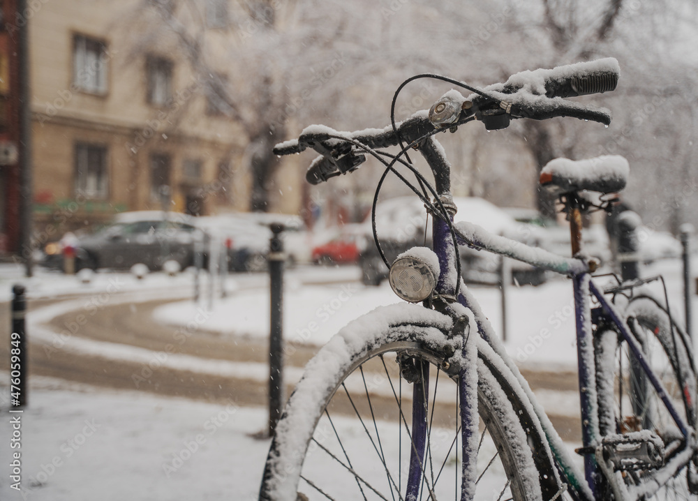Old retro bicycle in the snow on the city streets