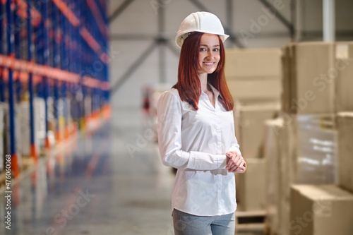 Woman in safety helmet standing in warehouse