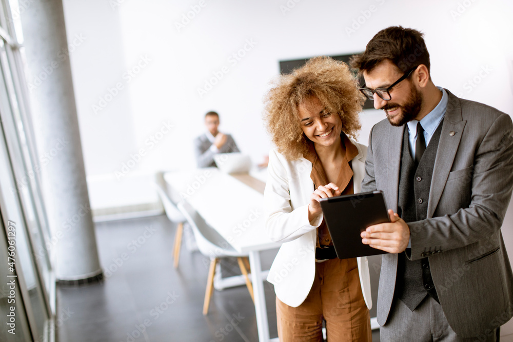 Young multiethnic entrepreneurs standing together and talking in the office