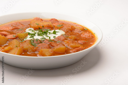 homemade dish so-called Erdapfelgulsch on a white plate with white background