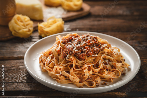 Foto Close up plate of pasta tagliatelle with BOLOGNESE SAUCE on wooden table