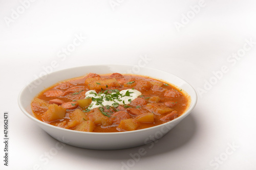 homemade dish so-called Erdapfelgulsch on a white plate with white background