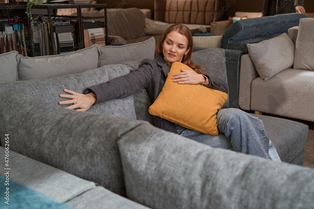 Obraz premium Concentrated lady selecting new couch in furniture store