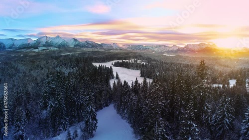 Snow capped mountains in the winter, aerial view. Aerial view of winter mountain landscape and colorful sunset sky. Tatra high mountains and magical unspoiled scenery.