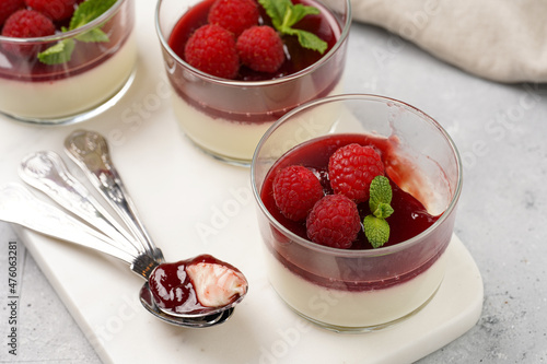 Italian dairy dessert panna cotta with raspberry jam, fresh raspberries and mint on marble board