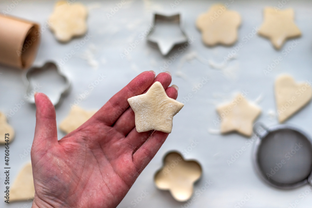 Top view of woman hands cooking a gingerbread cookie in the form of heart, star, cloud and flower. Christmas and New Year concept, festive preparations for winter hilodays Top view of woman hands cooking a gingerbread cookie in the form of heart, star, cloud and flower. Christmas and New Year concept, festive preparations for winter hilodays
