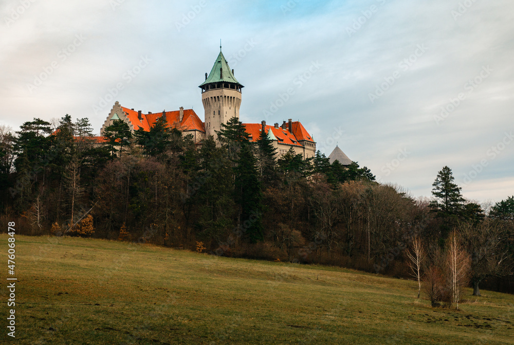 Beautiful scenic view of Castle Smolenice in Europe (Slovakia) on sunset. Fairy tale old and ancient castle with on meadow in autumn. Horizontal photo of romantic castle with blue cloudy sky.