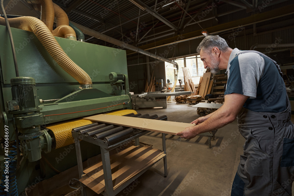 Focused photo on carpenter manufacturing mdf plank Focused photo on carpenter manufacturing mdf plank