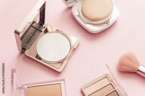 Make up layout,eye shadow, brush, and face powder on pastel pink background. Minimal and luxury make up, cosmetic or beauty salon composition. Flat lay, top view, copy space.