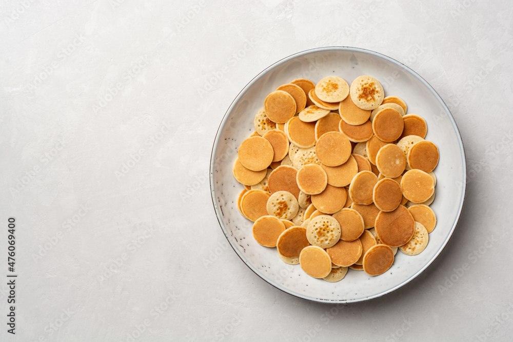 Pancake cereal or mini pancakes in plate on concrete background - obrazy, fototapety, plakaty 