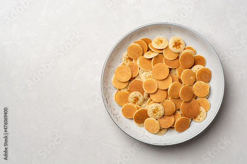 Pancake cereal or mini pancakes in plate on concrete background photo