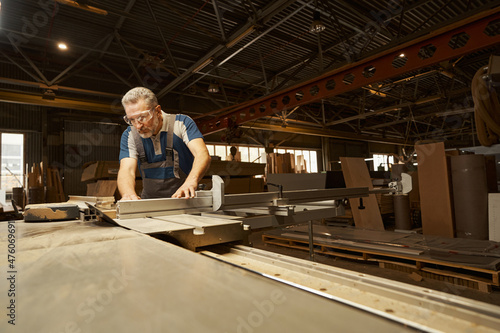 Fotografi Concentrated senior male joiner using woodworking machine