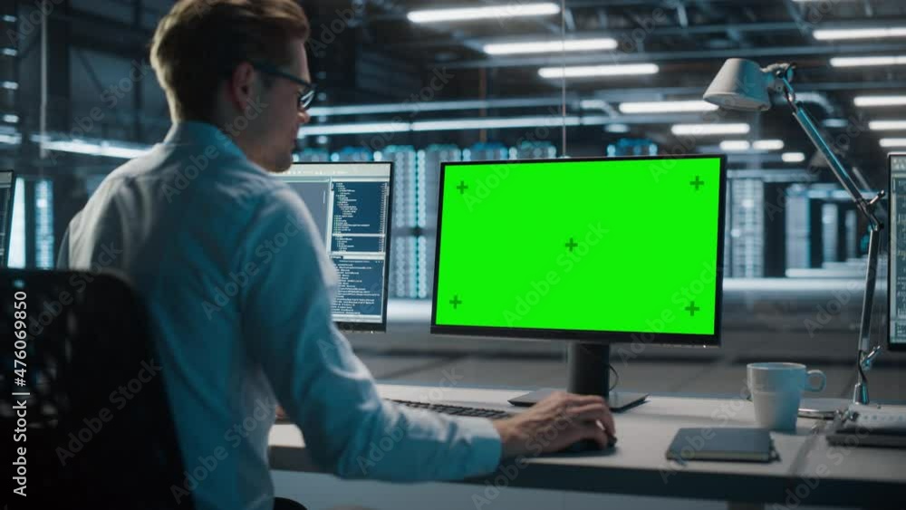 High-Tech Data Center Server: IT Specialist Administrator Working on Green Screen Chroma Key Computer. Monitoring Web Services, Cloud Computing, Analytics Facility, Maintenance of Cyber Security