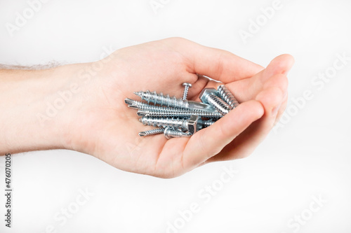 Building materials. Self-tapping screws in hand on a white background