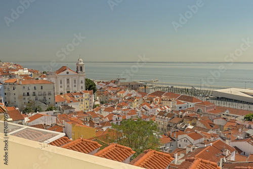 Tiled rooftops of the houses of Lisbon, with Tagus river in the background, Portugal photo