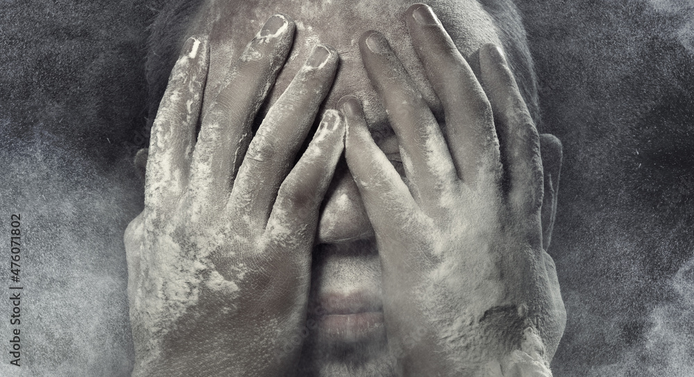 Man with hands on his face covered by the dust Man with hands on his face covered by the dust
